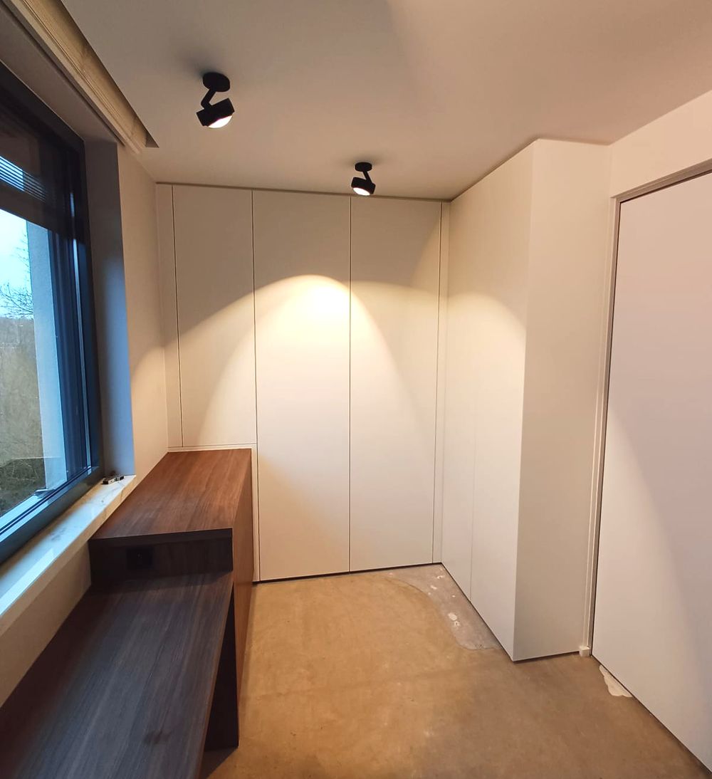 Witte kastenwand met houten zitbank