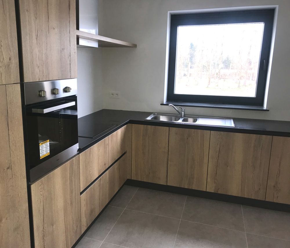 Houten keuken in L-vorm met zwart blad