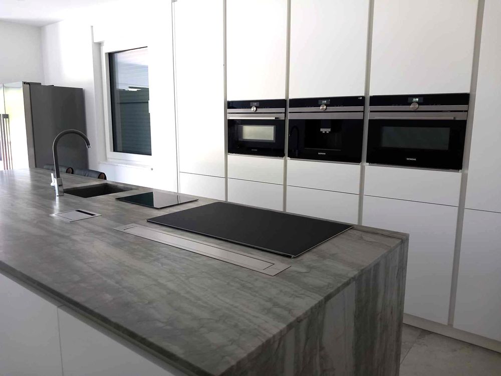 Witte kastenwand met betonlook eiland
