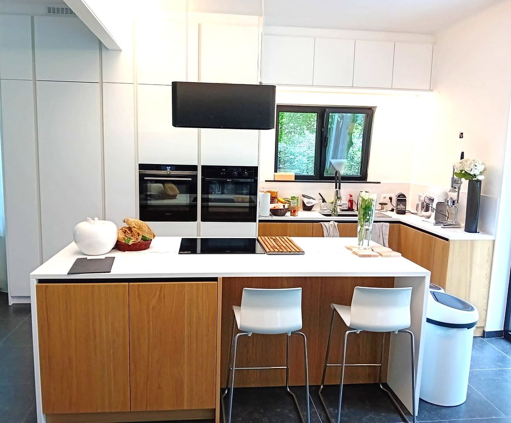 Witte keuken met houten eiland en zitbar