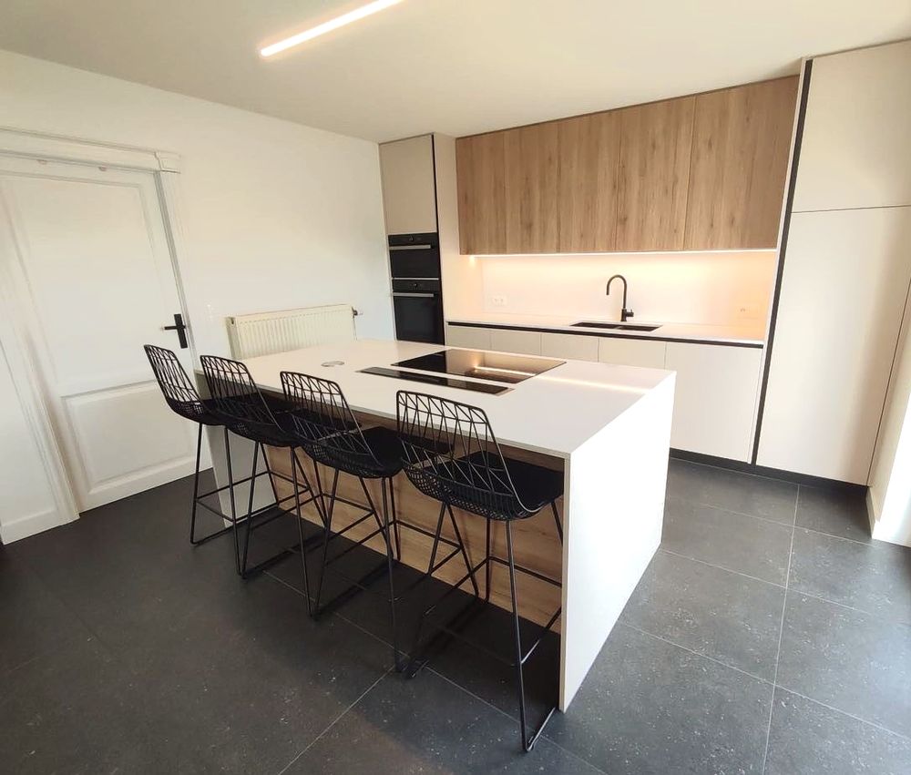 Witte keuken met houten kastenwand en zitbar
